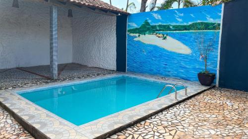 a swimming pool in a house with a painting on the wall at Casa Bem-Te-Vi | Alter do Chão in Alter do Chao