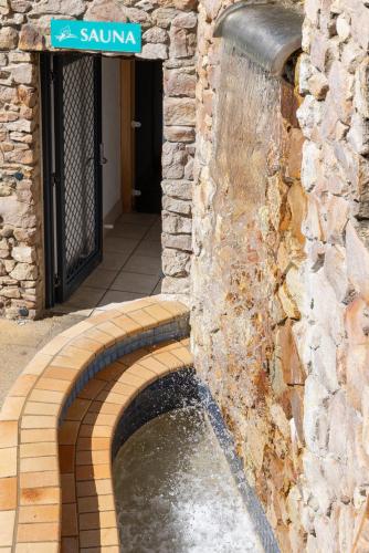 a water fountain in a stone building with a street sign at The Beach Retreat Coolum in Coolum Beach