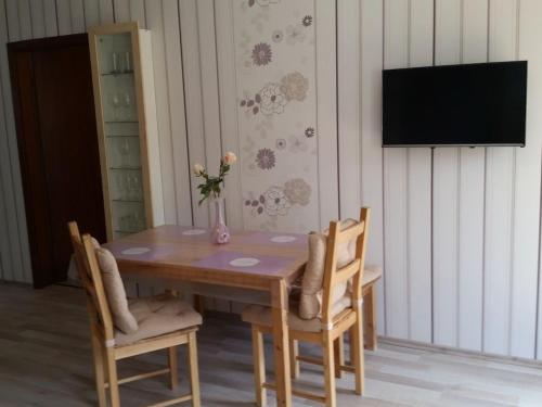 a wooden table with chairs and a vase with flowers on it at One-bedroom apartment in Möttau