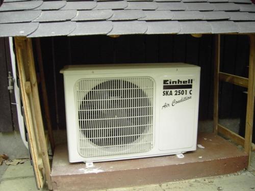 a fan sitting on the ground under a roof at Wooden holiday home with winter garden in Kleinweidelbach