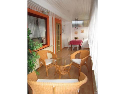 a room with a table and chairs and a dining room at Wooden holiday home with winter garden in Kleinweidelbach