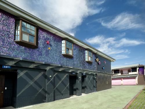 a building with a purple facade with windows at Fukun No. 3 Motel in Yilan City