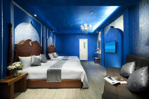 a blue bedroom with a large bed and a couch at Fukun No. 3 Motel in Yilan City