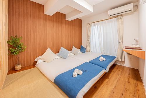 a bedroom with a large white bed with blue sheets at 桜の川10 池袋駅 7分 2-5人丨Ikebukuro 7 minutes 2-5 people in Tokyo