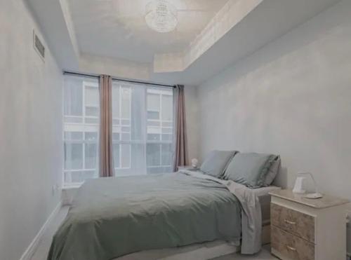 a bedroom with a bed and a large window at The Jazz Room in Toronto