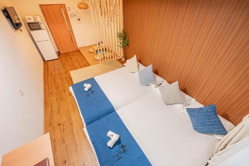 a bedroom with a bed with blue and white sheets at 桜の川10 池袋駅 7分 2-5人丨Ikebukuro 7 minutes 2-5 people in Tokyo