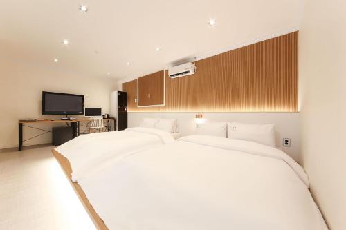 Ένα ή περισσότερα κρεβάτια σε δωμάτιο στο Gwangju W Lounge Hotel