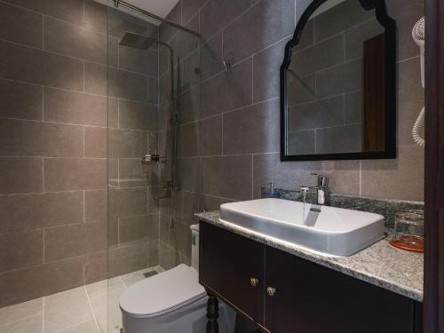 a bathroom with a sink and a toilet and a mirror at Lumina Dalat Premium in Xuan An