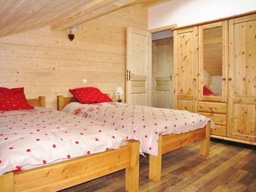 una camera da letto con un letto grande con cuscini rossi di Chalet confortable à Samoëns, 10 pers, 4 chambres, WIFI, parking - FR-1-815-47 a Samoëns