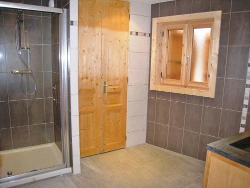 bagno con doccia e porta in legno di Chalet confortable à Samoëns, 10 pers, 4 chambres, WIFI, parking - FR-1-815-47 a Samoëns