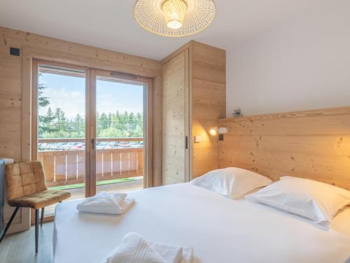 a bedroom with a large bed and a large window at Appartement moderne, Alpe d'Huez, 6 pers, cosy et pratique - FR-1-645-87 in L'Alpe-d'Huez