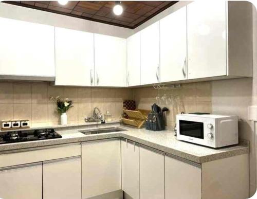 a kitchen with white cabinets and a microwave at FLYING Stay 플라잉스테이 in Seoul