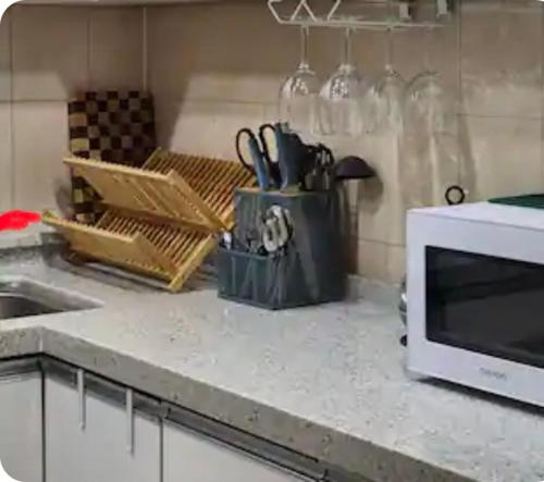 a kitchen counter with a sink and a microwave at FLYING Stay 플라잉스테이 in Seoul