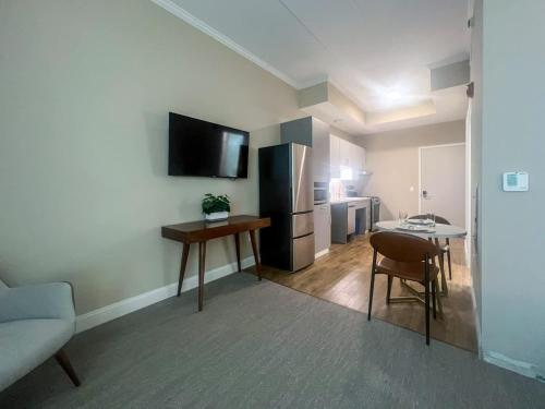 a living room with a kitchen with a table and a refrigerator at 403 Modern Brand New Studio Apartment in East Spotswood