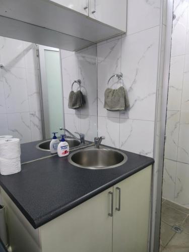 スバにあるDoctors Apartmentの洗面台と鏡のあるバスルーム