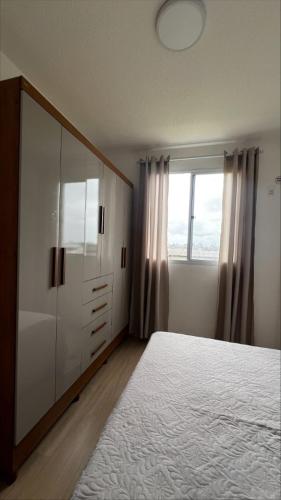 a bedroom with a bed and a dresser and a window at Conquista Salvador in Salvador