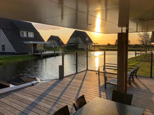a wooden deck with a view of a body of water at Lakeside Villa with Terrace in Delfstrahuizen
