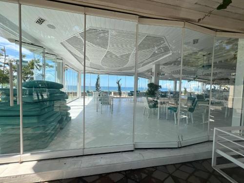 a building with glass walls and tables and chairs at Dream Land Oasis 14-704 apartment in Chakvi