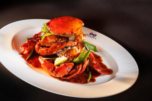a white plate of food with shrimp and vegetables at Anantaya Resort & Spa Chilaw in Chilaw
