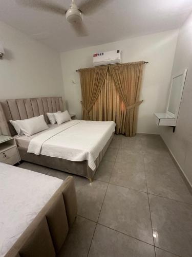a bedroom with two beds and a heater on the wall at Seaview Residency in Karachi