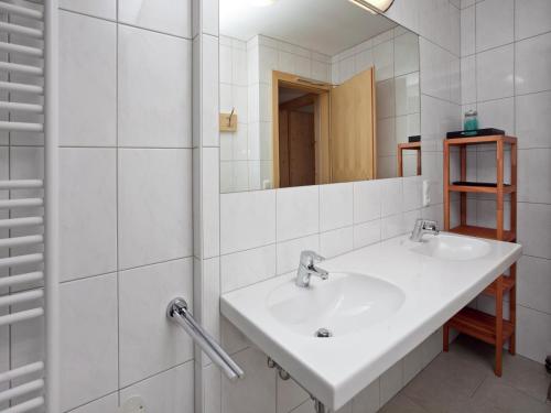 Un baño blanco con dos lavabos y un espejo. en Chalet in Königsleiten near Ski Lift, en Wald im Pinzgau