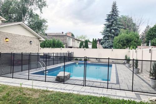 a swimming pool with a fence around it at Stylish 2bed, 2bth Apt Malls & 25 Mins To Toronto in Mississauga