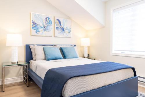 a bedroom with a blue and white bed with two lamps at Stylish 2bed, 2bth Apt Malls & 25 Mins To Toronto in Mississauga