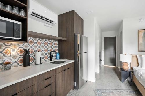 a kitchen with a sink and a refrigerator at Adelynn Studio Walkable Kerns Spanish Charm in Portland