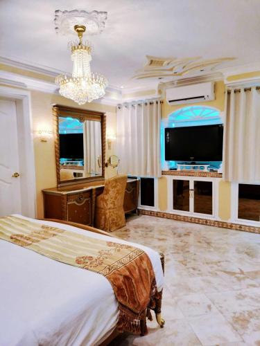 a bedroom with a bed and a flat screen tv at Breakfast at Monaco - Palais Boracay in Boracay