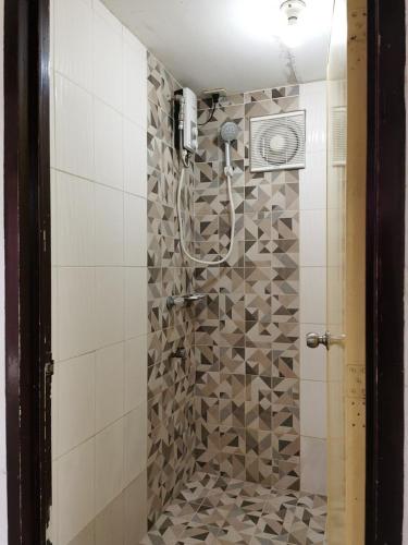 a shower in a bathroom with a tile wall at Zen Lian Private Resort in Lian