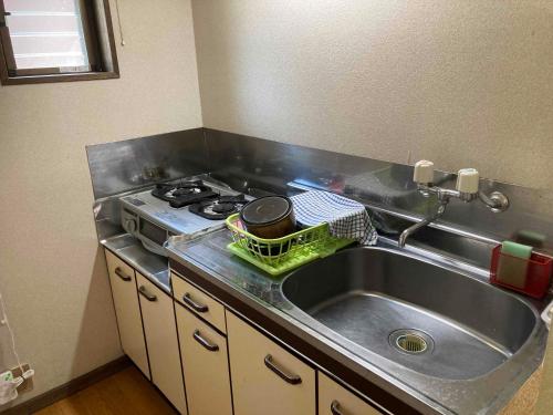 a kitchen with a sink and a stove at Soratobu Usagi in Myoko