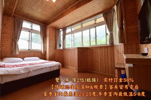 a bedroom with two beds in a room with windows at 溪頭桂竹山莊民宿 in Lugu