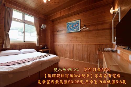 a bedroom with a bed and a tv in a room at 溪頭桂竹山莊民宿 in Lugu