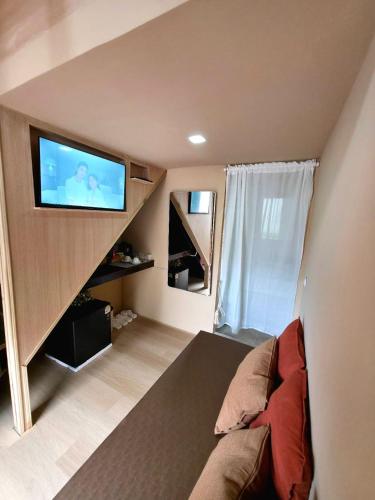 a living room with a couch and a tv on the wall at Blu Cabin Ari Stylish Gay Poshtel in Bangkok