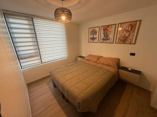 a bedroom with a bed and a large window at Comodo y hermoso departamento en centro histórico in Santiago
