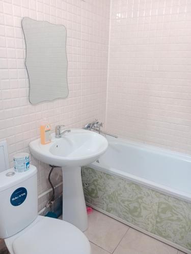 a bathroom with a sink and a toilet and a tub at Металлург in Ustʼ-Kamenogorsk