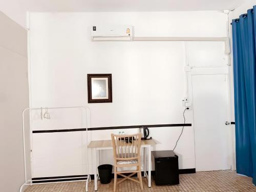 une chambre avec une table et un rideau bleu dans l'établissement Toss Inn Hat Yai OldTown - ทอส อินน์ หาดใหญ่ ตลาดกิมหยง, à Hat Yai