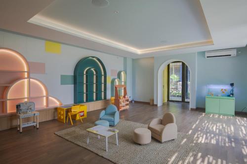 a childrens room with chairs and tables and a living room at Plataran Puncak Suites in Puncak