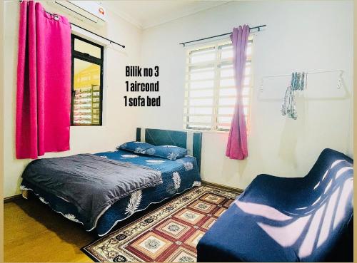 a bedroom with a bed and a chair at IMAN Homestay in Melaka