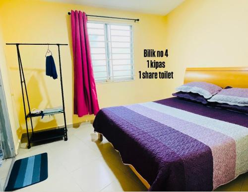 a bedroom with a bed with a sign on the wall at IMAN Homestay in Melaka