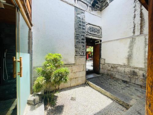 an open door of a building with a potted plant at Dali Xizhou Jiakedi 大理喜洲甲科第古宅文化民宿 in Dali