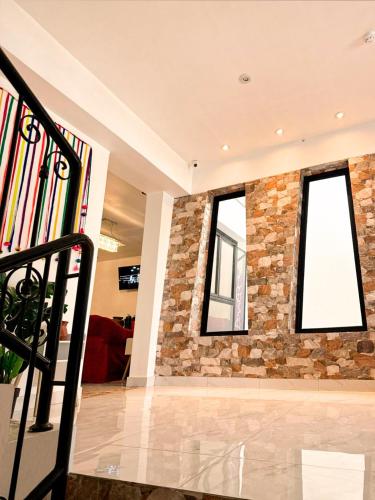 a lobby with two windows and a stone wall at Hotel 8 Retablos in Ayacucho