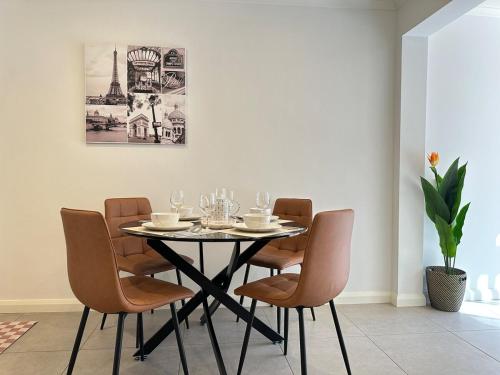 a dining room table with chairs and a picture of the eiffel tower at Charming 2BR Cottage in City Fringe Norwood in Rose Park