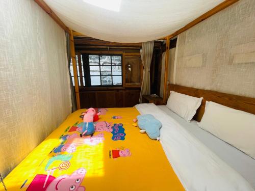 a bedroom with a bed with toy animals on it at Dali Xizhou Jiakedi 大理喜洲甲科第古宅文化民宿 in Dali