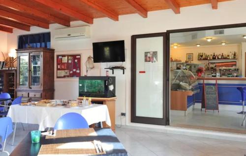 a dining room with a white table and a tv at Su Pasu in Tortolì