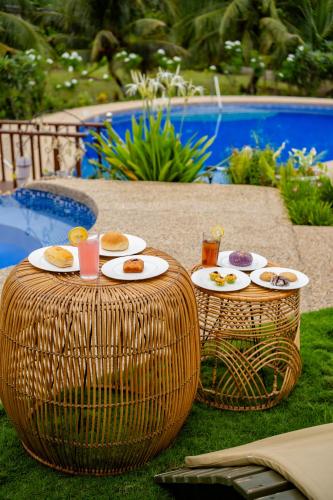 a table with plates of food on it next to a pool at Lovenista Retreat and Camping Site - Tiny House 