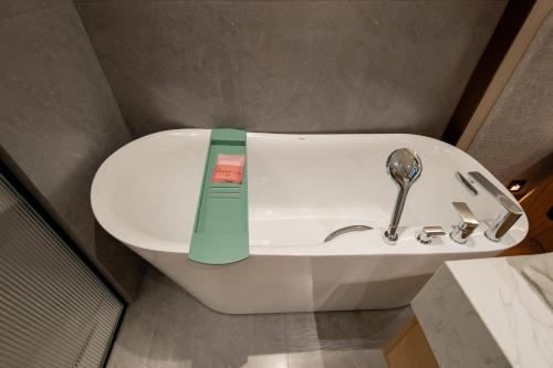 a white sink in a bathroom with a thermometer at Floral Hotel Taipingli in Quanjiao