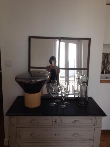 une personne prenant une photo d'un miroir sur une commode dans l'établissement Appartements de Jules & Victoire, à Pornic