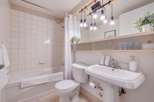 a bathroom with a sink and a toilet and a tub at 2BR Yorkville Condo - Self Check In & Free Parking in Toronto