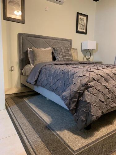 a bedroom with a bed with a gray comforter at Urban Loft in Falmouth